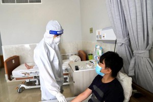 医护人员在给一名新冠肺炎患者把脉并问诊临床症状。（示意图：互联网）