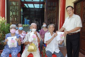 二府会馆副理事长谢忠成（右一）向高龄乡亲赠送粽子。