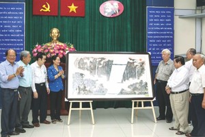 市委副书记、市人民议会主席阮氏丽接收第五郡华人会馆赠送的水墨画纪念品。