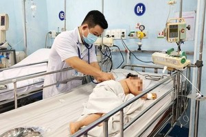 医生正给在市第一儿童医院接受治疗的手足口病儿做检查。