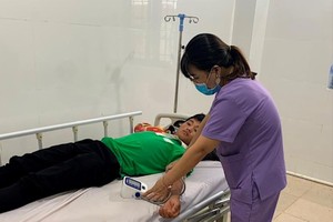 德农省德格隆县医疗中心医护人员正为一名食物中毒者把脉量血压。（图：德农报）