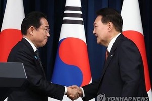 5月7日，在首尔龙山总统府，韩国总统尹锡悦（右）和日本首相岸田文雄在会后举行的联合记者会上握手。（图：韩联社）