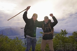 在迎来开山的富士山半山腰附近，外国登山客背向朝阳发出欢呼声。摄于7月1日。（图：共同社）