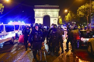 图为当地时间7月1日晚，法国警察在巴黎香榭丽舍大街的凯旋门前巡逻。（ 图：AFP）