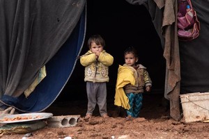 在叙利亚南部的一个非正式营地中，流离失所儿童站在自家的帐篷前。（图：联合国）