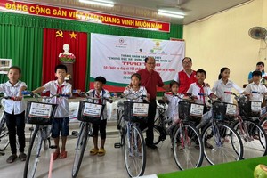 温陵会馆理事长洪世真(后排左一)与红十字会代表赠送自行车给学生。