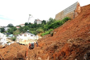 带有混凝土的土石崩落到下面大勒市黄花探街36号小巷，导致两人死亡。