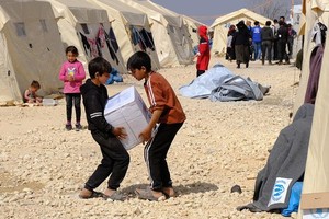 在叙利亚境内流离失所者营地，儿童正在搬运救援物资。（图：联合国）