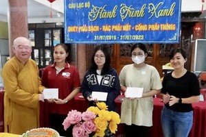 莲华寺住持、“绿色环保”俱乐部主任释惟镇法师向学生颁发奖学金。