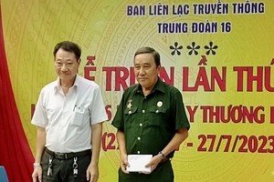 茶山庆云南院住持周华邦（左）向第16团传统联络处代表移交5000万元建“同队屋”工程。