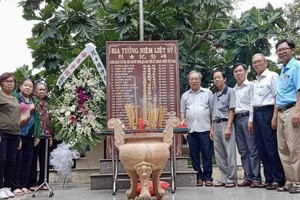 市华人抗战传统俱乐部主任孙盛强、市民族处副主任曾福禄以及海南会馆诸位理事会代表在琼裔烈士纪念碑前合照留念。