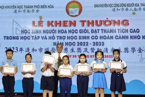 边和市华人励学会主任黄有义向华人子弟颁奖。