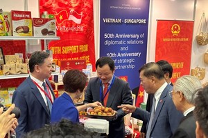 梅福勇大使与高春胜商务参赞请参观者品尝越南的新鲜荔枝。