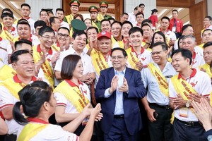 政府总理范明政与全国模范志愿捐血者会唔。（图：越通社）