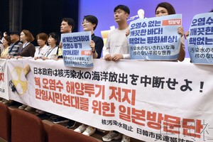 图为在禁止原子弹氢弹世界大会上举出反对排放处理水横幅的韩国市民团体成员等。7月30日摄于福岛市。（图：共同社）