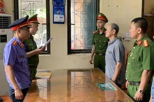 执法警员向嫌犯范嘉律宣读拘捕令。（图：河南公安）