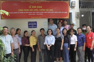 华文《西贡解放日报》和郡、坊领导向华人荣军移交“情义屋”。