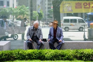 韩国首尔，两名老人在长凳上聊天。（图：CNN）