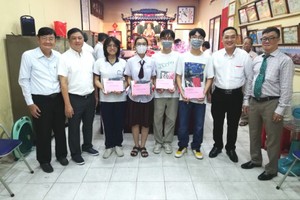 理事长关贵鸿(右一)与领奖学生合照。