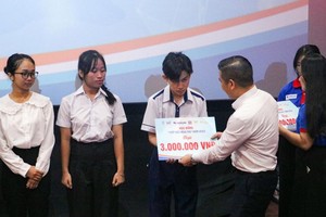 天龙集团代表郑文豪颁发助学金给贫困生。