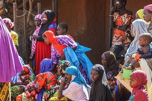 妇儿在尼日尔塔瓦地区的粮食计划署分发处等待领取口粮。（图：联合国）