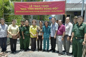 茶山庆云南院住持周华邦（右五）与各赞助单位代表和地方领导向退伍军人移交“情义同队屋”工程。