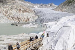 图为因消融速度加剧而被白毯覆盖的阿尔卑斯山罗讷冰川。（图：新华社）