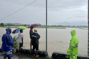 9月3日，菲律宾北部南伊罗戈省圣卢西亚市，当地救灾人员在帕拉通社区一座大桥上查看水情。(菲律宾圣卢西亚市警察局 供图)