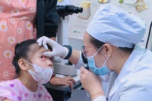 眼科医生在为一名病童仔细检查眼睛。（图：维姜）