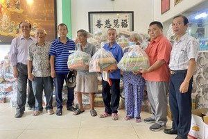 福慧慈善组代表、来宾与赞助商赠送礼品予穷人。