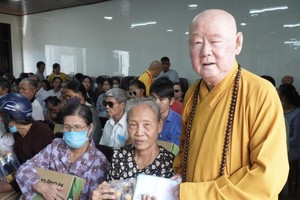 第十一郡莲华寺住持释惟镇法师向少数民族同胞派发礼物。