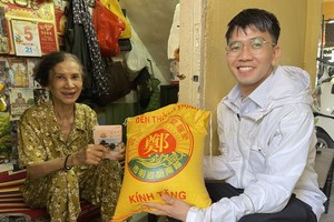 年轻画家范哲（右）向龚有好大娘转送郑氏大宗祠的爱心。