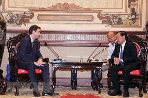 市人委会主席潘文迈（右）接见 IMF常驻越南代表约亨.施密特曼(音)教授。（图：越通社）