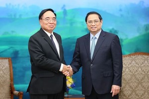 政府总理范明政（右）接见老挝计划投资部长、老-越合作委员会主席坎詹‧冯福西(音)。（图：越通社）