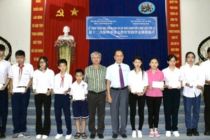 越南台商奖学金基金会董事长苏建源（右六）与华文《西贡解放日报》编委黎曰孟雄（右七）向学生颁发奖助学金。