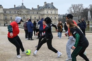 法国去年禁止女球员戴头巾上场后，一些穿戴头巾的女性在法国参议院附近踢球以示抗议。图：AFP）
