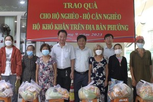 茶山庆云南院住持周华邦（右六）与地方领导向贫困者派发礼物。