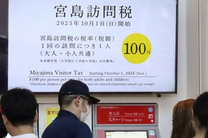 图为渡轮码头上关于“宫岛访问税”的说明。（图：共同社）