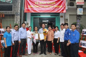 郡、坊领导和庆云南院住持周华邦向华人户移交“友情屋”工程。