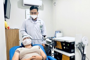 黎曰胜医生为一名慢性头疼患者治疗。