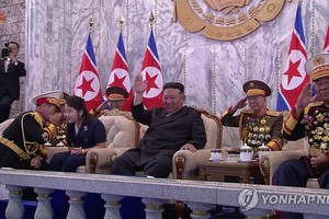 9月9日，在朝鲜庆祝建政75周年阅兵式上，劳动党军政指导部部长朴正天（左）单膝跪地同金主爱（音）交谈。（图：韩联社/朝鲜中央电视台）