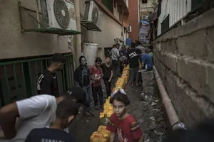 加沙南部汗尤尼斯一处临时难民营的巴勒斯坦民众周三排队等待取水。（图：EPA）