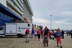 “精致邮轮极号”邮轮停泊在下龙国际客运港码头，游客纷纷上岸游览参观下龙湾。（图：吕孝义）