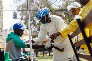 在津巴布韦哈拉雷，医护人员帮助一名霍乱患者。（图：AFP）
