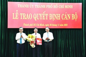 市委书记阮文年与市委副书记、市委组织处主任阮福禄向范鸿山同志颁授《决定》。