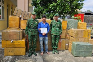 被抓获的犯罪嫌疑人邓阮黄康（中）及物证。（图：明伦）