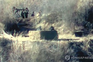 图为朝军将重武器搬进哨所。（韩联社/国防部供图）