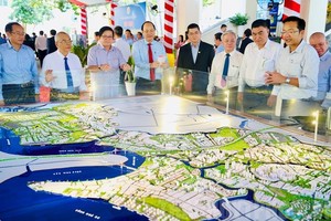 市委副书记阮胡海同与会代表观看芽贝县沙盘模型并探讨投资机会。（图：市党部新闻网）