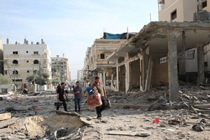 在加沙，人们走在被摧毁的街道上。（图：联合国）