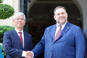 市人委会副主席武文欢（左）与白俄罗斯外交部副部长叶夫根尼‧谢斯塔科夫握手合影。（图：越通社）